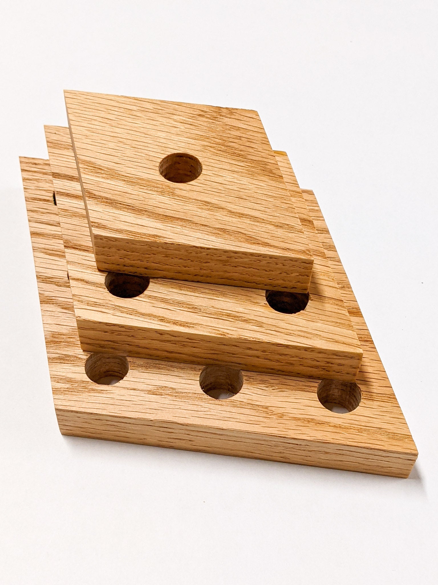 A set of three rhombus propagation shelves sit one on top of the other with the largest at the bottom and the smallest on top.